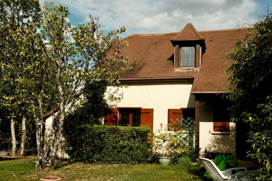 Détecteur extérieur d’alarme installé sur la terrasse d’une maison moderne en France, sécurisant le jardin dans une ambiance rassurante