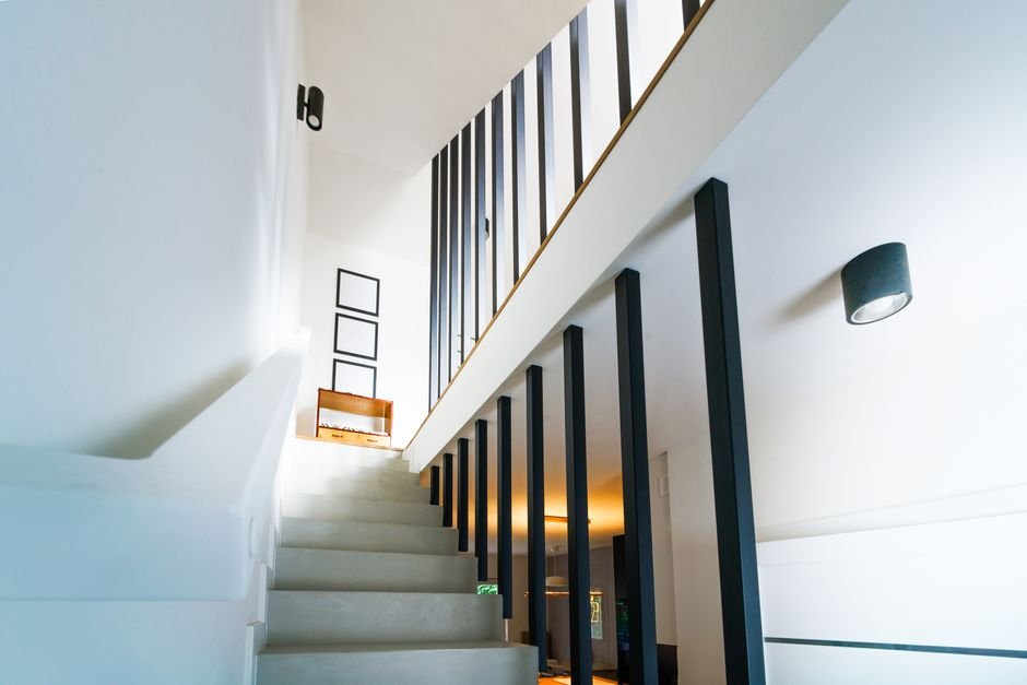 Vue d’un couloir lumineux dans une maison à étage moderne en France, avec détecteur de mouvement installé sur le mur, illustrant le placement optimal pour éviter les angles morts