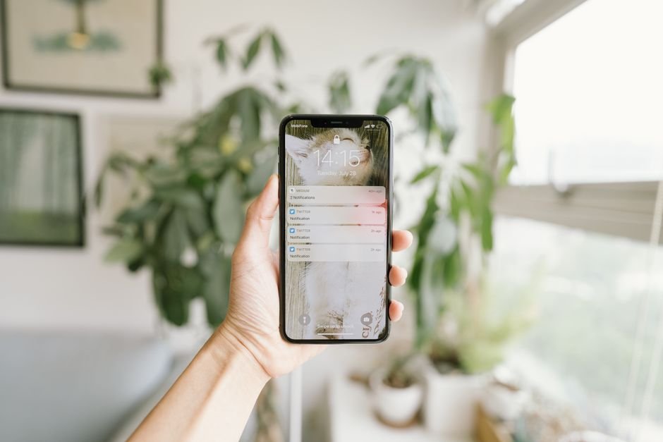Main recevant une alerte de sécurité GSM sur smartphone dans une habitation française, démontrant la continuité des notifications sans connexion Internet